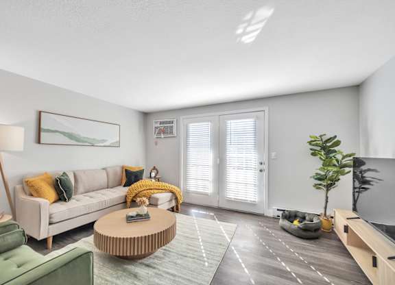 A living room with a sofa, a coffee table, and a green armchair.