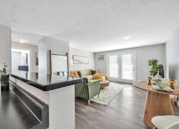 A modern kitchen with a dining area in the background.
