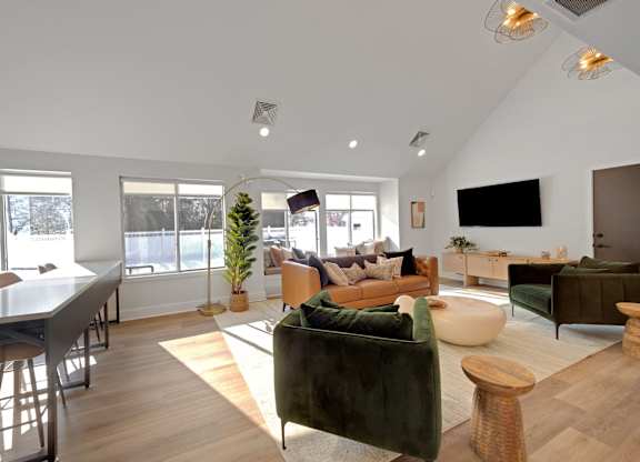 A living room with a green couch and a wooden floor.