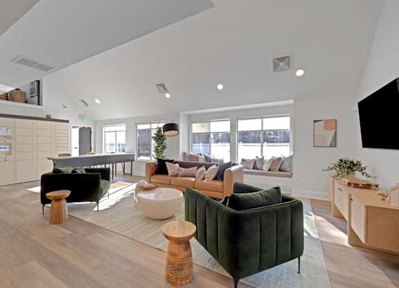 A living room with a green couch and a wooden floor.