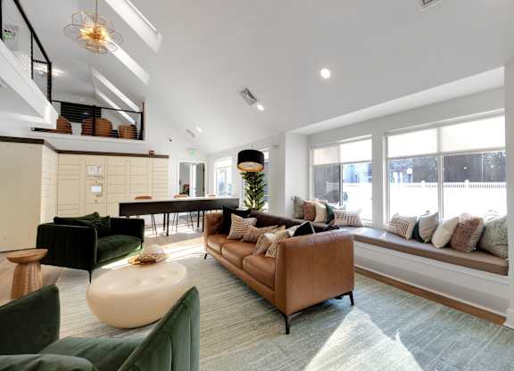 A living room with a brown sofa and a green armchair.