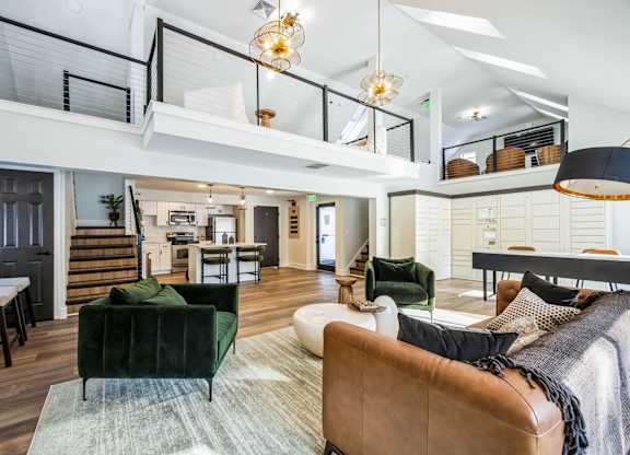 A living room with a green couch and a brown leather chair.