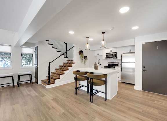 A modern kitchen with a dining table and chairs.