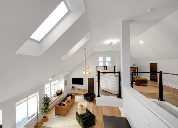 A modern living room with a skylight and a large couch.