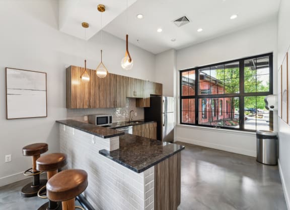 a kitchen with a bar and stools in front of a large window in the clubhouse at The Tannery, Connecticut