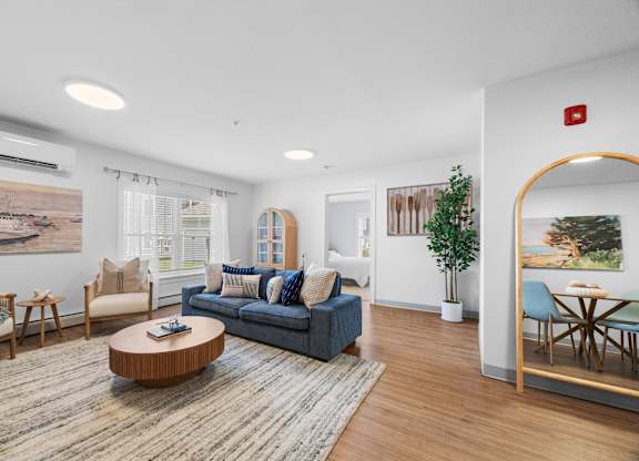 A living room with a blue couch and a wooden coffee table.