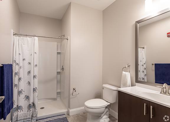 A bathroom with a toilet, sink, and shower.