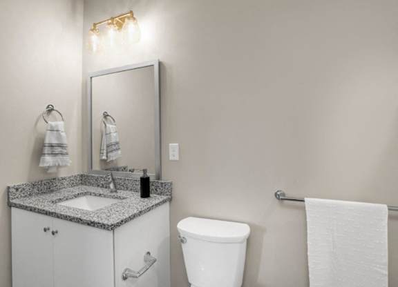 a bathroom with a sink toilet and a mirror