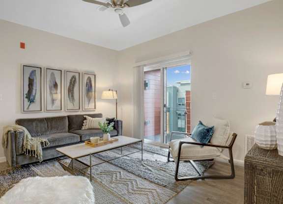 A living room with a grey couch, a coffee table, and a chair.