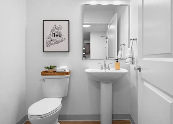 A white toilet sits next to a white sink in a bathroom.
