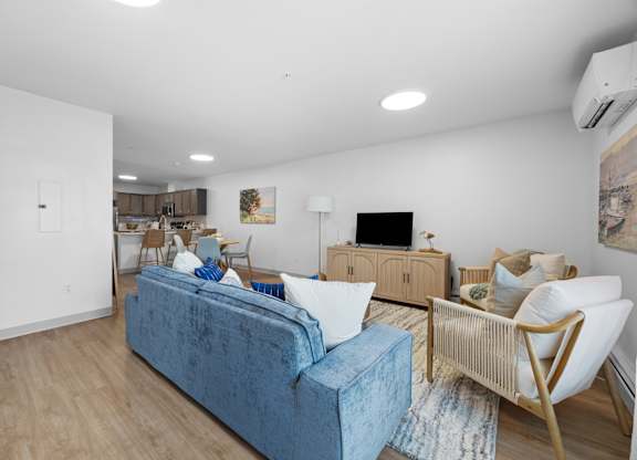 A living room with a blue couch and a wooden chair.