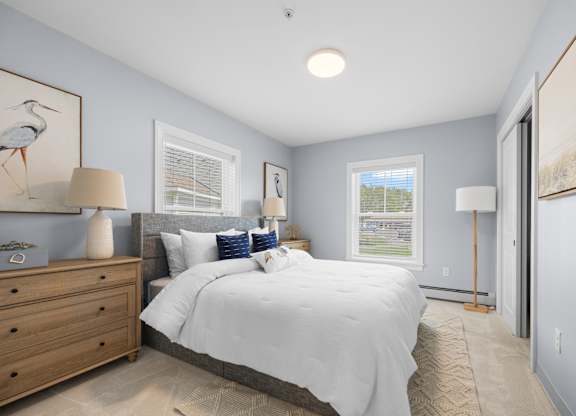 A bedroom with a large bed and a painting of a bird on the wall.