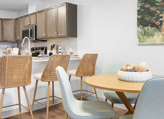 A kitchen with a table and chairs.