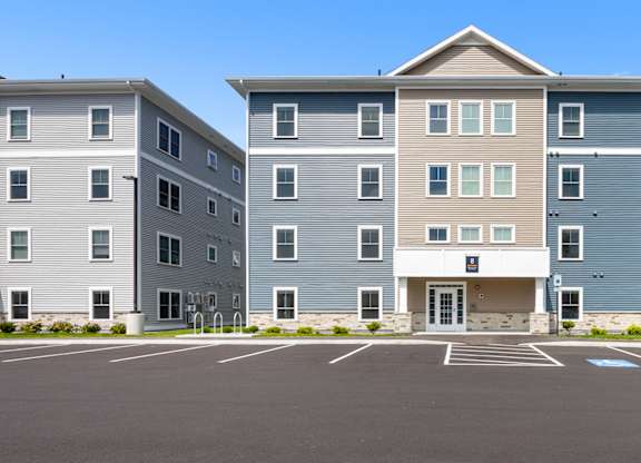 A large building with a parking lot in front.