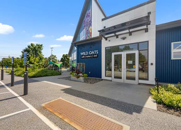 The Wild Oats store is a blue and white building with a sign on the front.