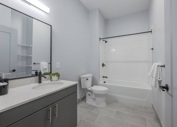 A bathroom with a white toilet, sink, and bathtub. at Seacoast Residences Apartments, Oakland, ME, 03904