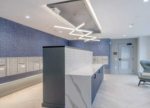 A modern office lobby with a reception desk and a chair at Seacoast Residences Apartments, Maine