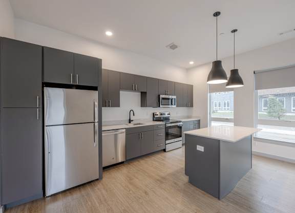 A modern kitchen with stainless steel appliances and wooden floors at Seacoast Residences Apartments, Oakland