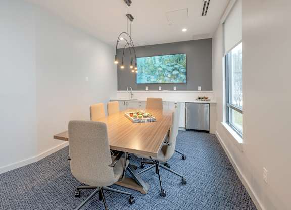 A conference room with a table, chairs, and a TV on the wall at Seacoast Residences Apartments, Oakland, ME, 03904