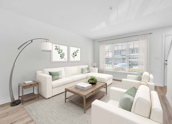 A living room with a white couch, a wooden coffee table, and a floor lamp at Windsor Terrace, Hooksett, NH