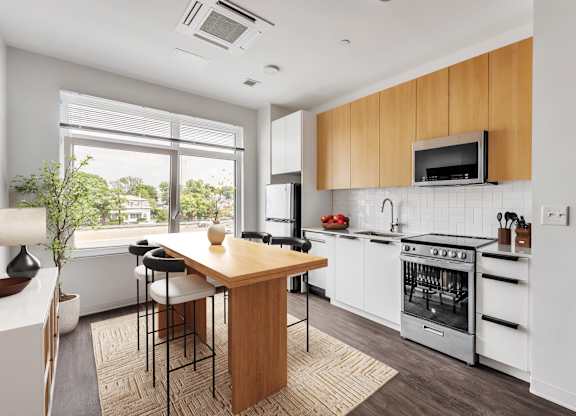 A modern kitchen with white appliances and wooden cabinets.