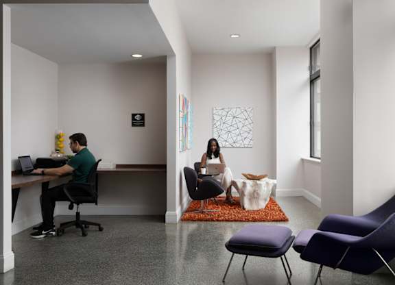 a man and a woman sitting at a desk in an office