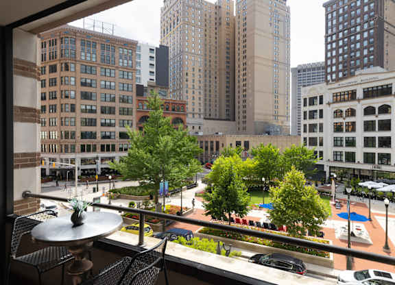 a view of the city from a window with trees and tall buildings