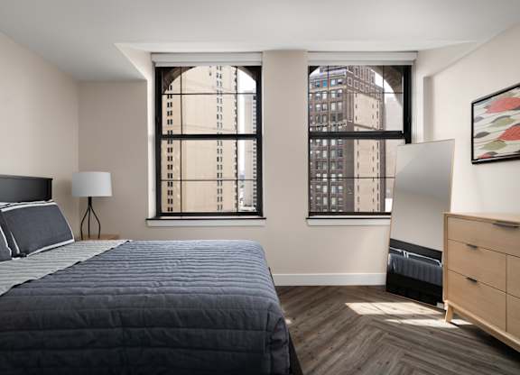 a bedroom with a bed and two windows