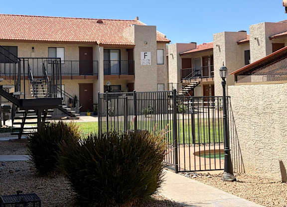 A row of houses with a black fence in front.