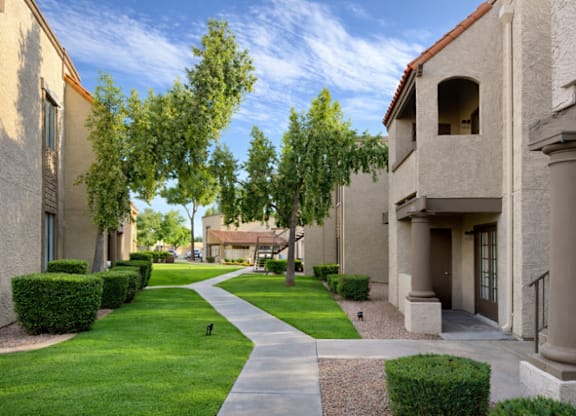 A pathway leads through a grassy area between two rows of buildings.