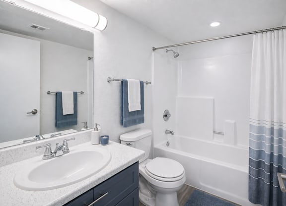 A white bathroom with a toilet, sink, and bathtub.