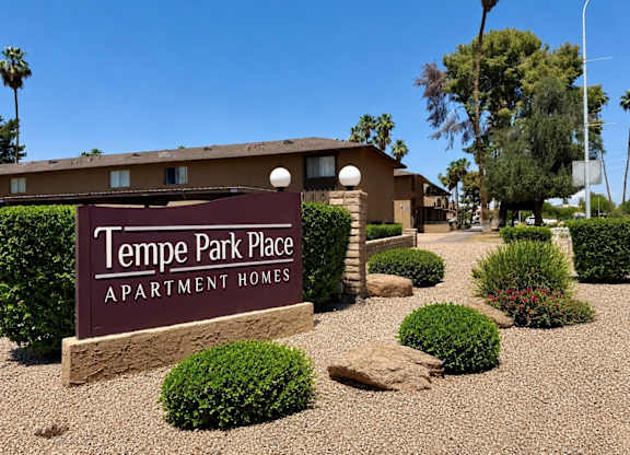 The image shows the front of Tempe Park Place Apartment Homes with a clear blue sky in the background.