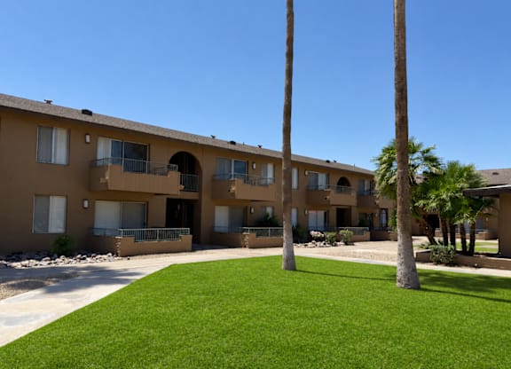 Apartment complex with a green lawn in front.