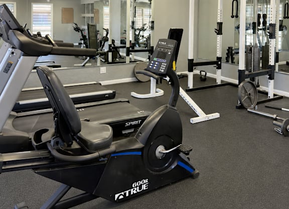 A gym with a rowing machine in the foreground.