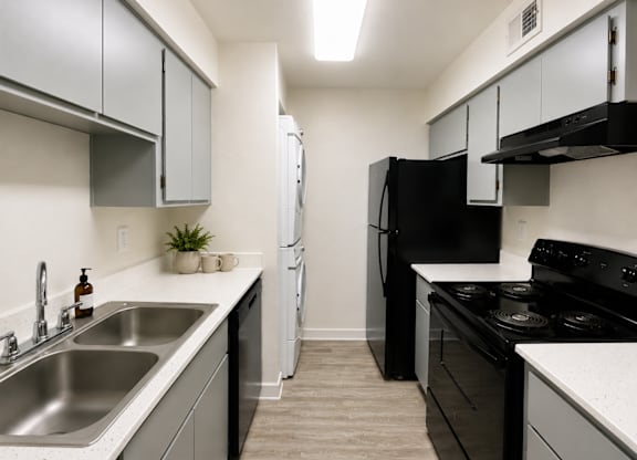A kitchen with black appliances and white countertops.