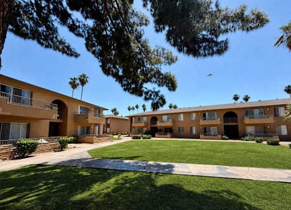 A bird flies over a courtyard surrounded by apartment buildings.