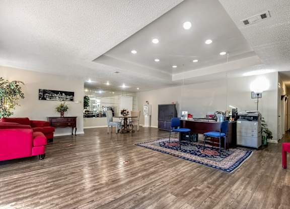 A living room with a red couch and a blue chair.
