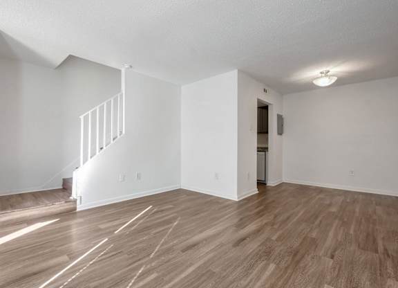 A room with wooden floors and a staircase.