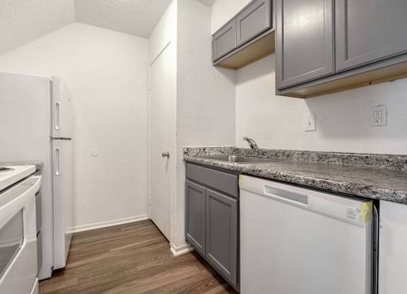 A kitchen with a white fridge, a white dishwasher and a white oven.
