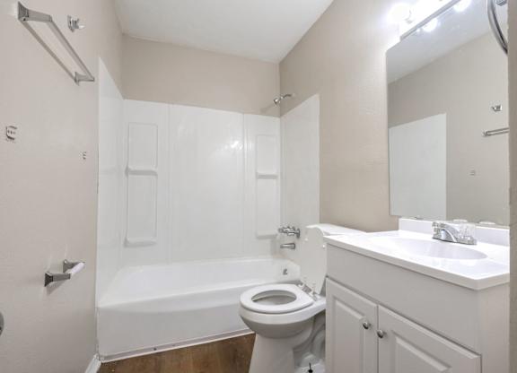 A white bathroom with a toilet, sink, and bathtub.