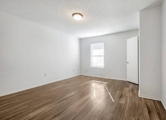A room with wooden flooring and a window.