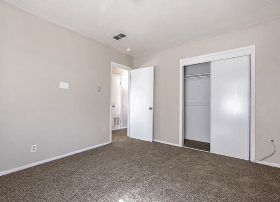 A room with a carpeted floor and a white door.