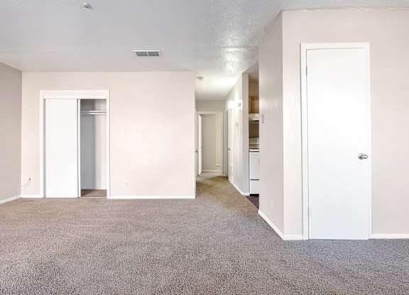 A spacious room with carpeted floor and white walls.