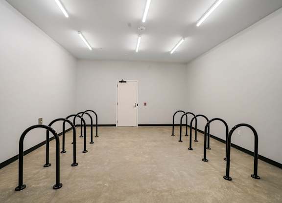 A white room with a white door and black bars on the floor.