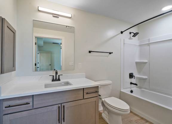 A white bathroom with a sink, toilet, and bathtub.