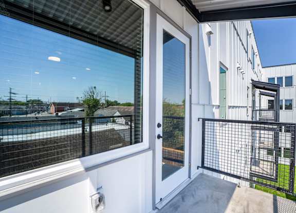 A balcony with a view of a pool and a building.