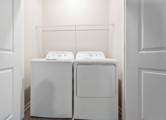 Two white washing machines in a laundry room.