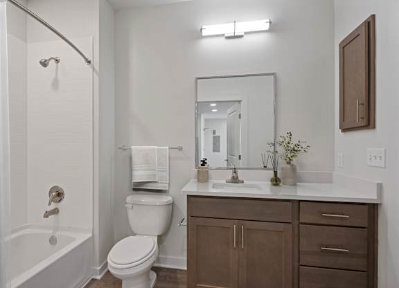 A white bathroom with a toilet, sink, and bathtub.