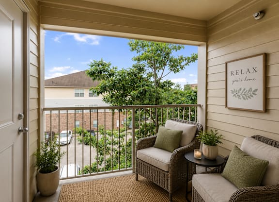 A balcony with a sofa and a table with a candle on it.