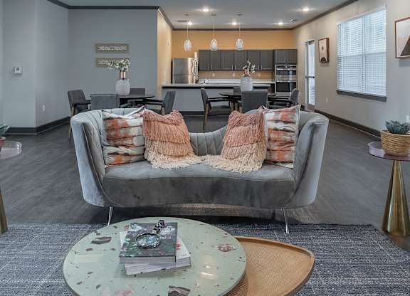 A grey couch with pillows and blankets is in the foreground of a modern living room.